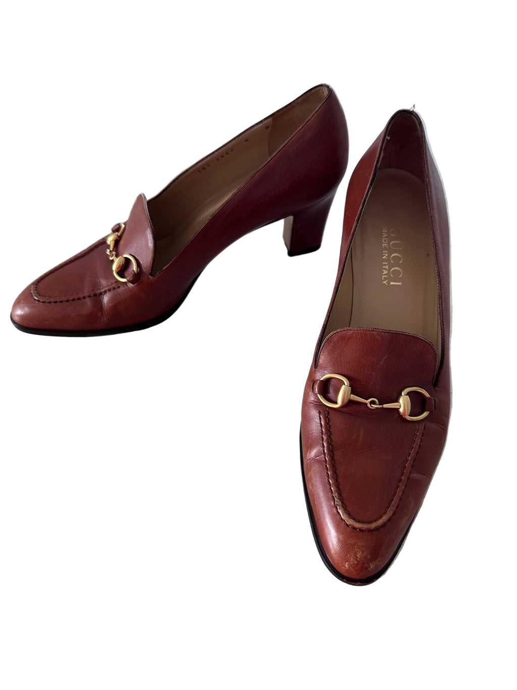 Pair of brown leather vintage Gucci shoes with gold accents on a white background