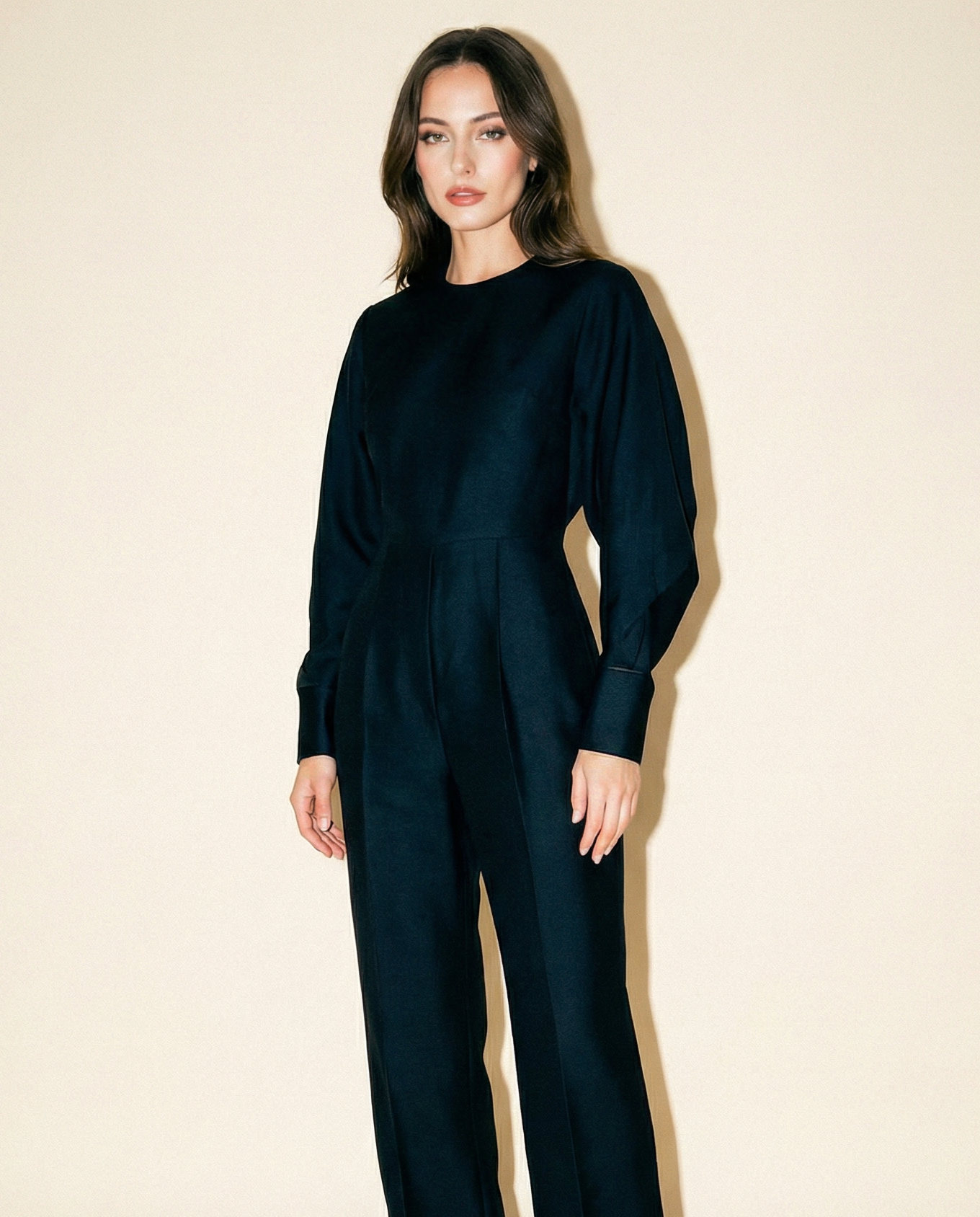 Woman wearing a black vintage stella mccartney jumpsuit against a beige background